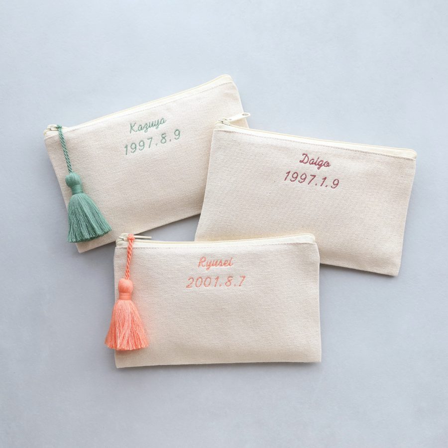 名前と記念日を推しカラーの糸で刺繍したお揃いのポーチ3点。推し活仲間やライブ遠征に