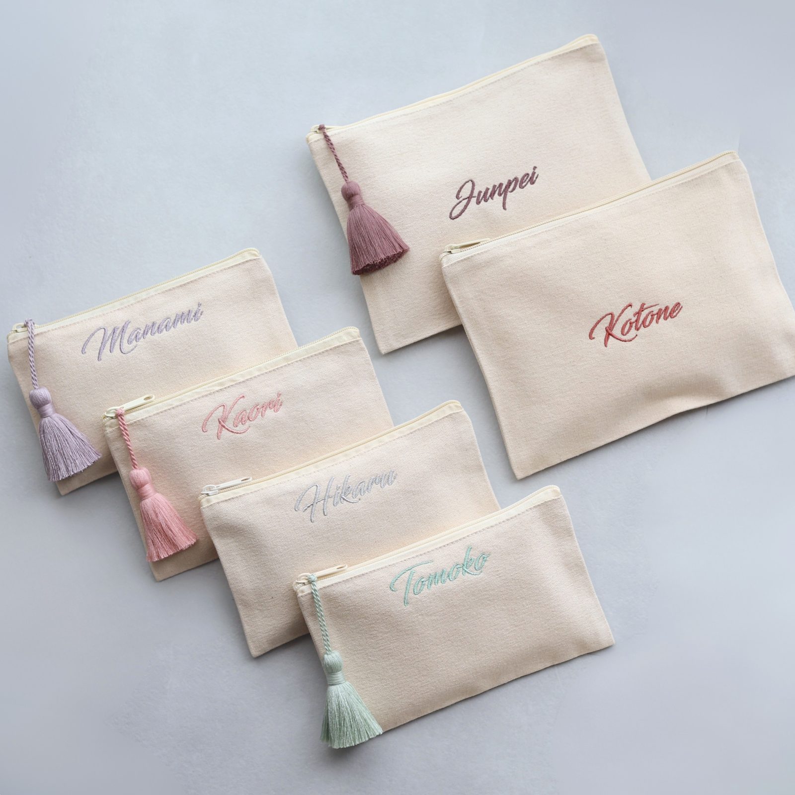 筆記体で名前を刺繍した名入れ刺繍ポーチ。色違いの刺繍糸とタッセルで。MIMARCA（ミマルカ）